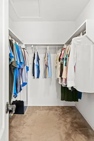 a view of walk in closet with clothes