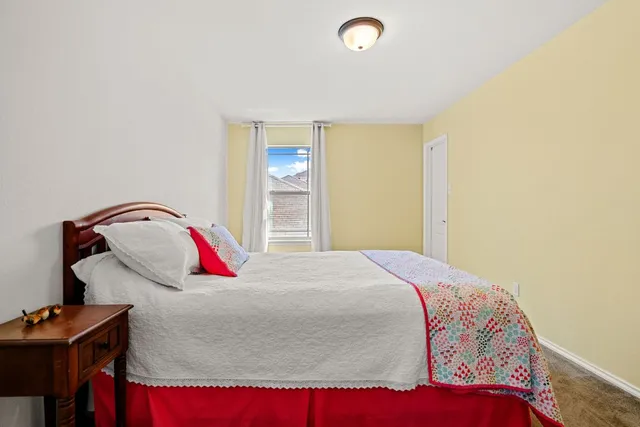 a bed sitting in a bedroom next to a window