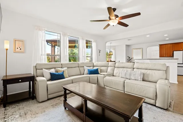a living room with furniture ceiling fan and a window