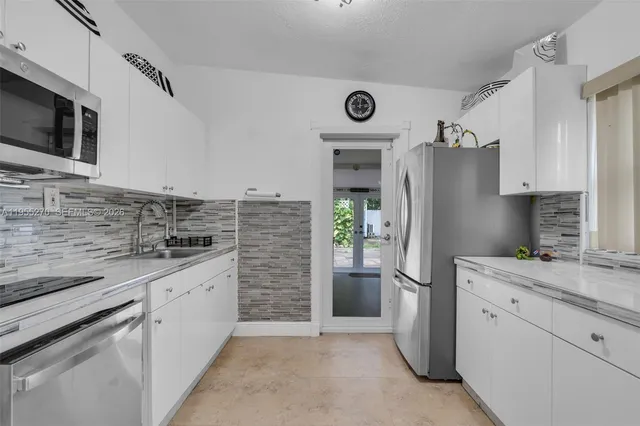 a kitchen with stainless steel appliances a refrigerator stove microwave and sink