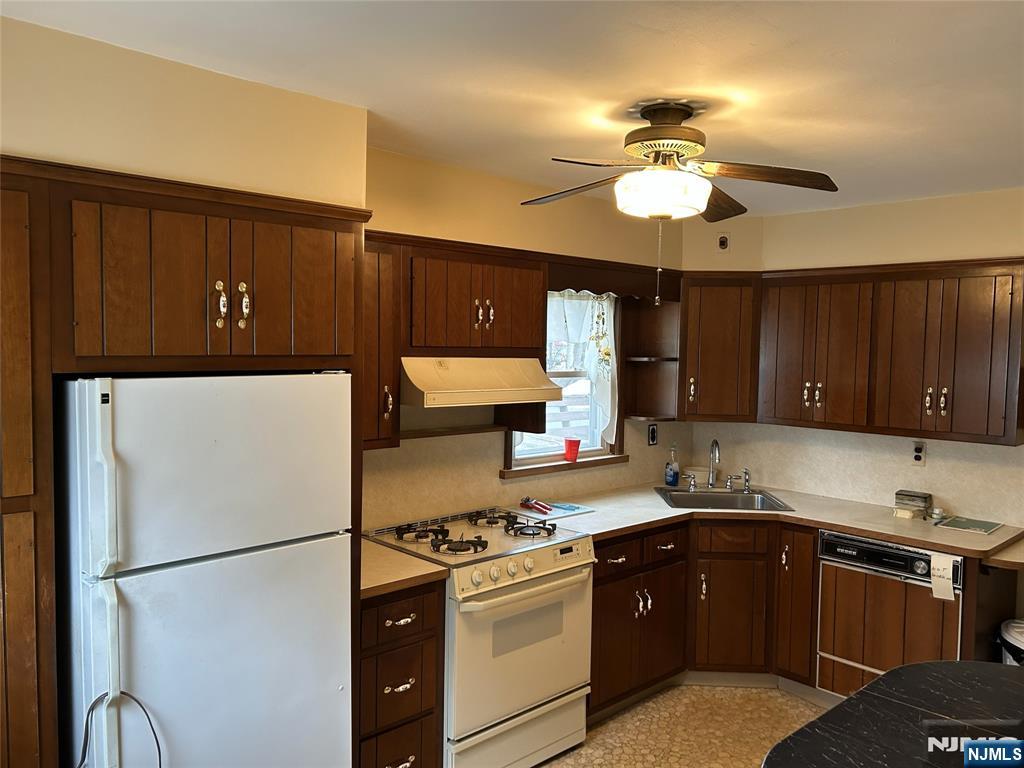 47 Ryle Avenue Little Falls, NJ 07424 - Photo 7 of 18 a kitchen with a refrigerator a sink and cabinets