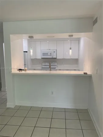 a kitchen with granite countertop a cabinets and white stainless steel appliances