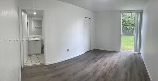 an empty room with wooden floor and sliding door