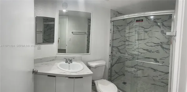 a bathroom with a sink toilet and shower