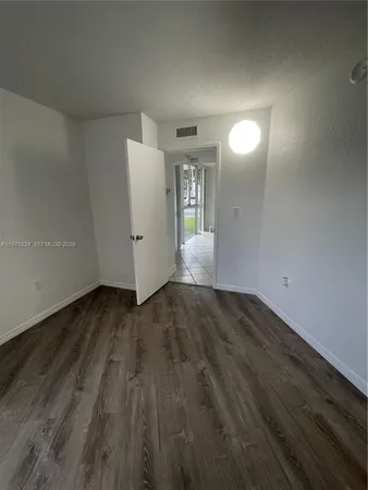 a view of a room with wooden floor and white walls