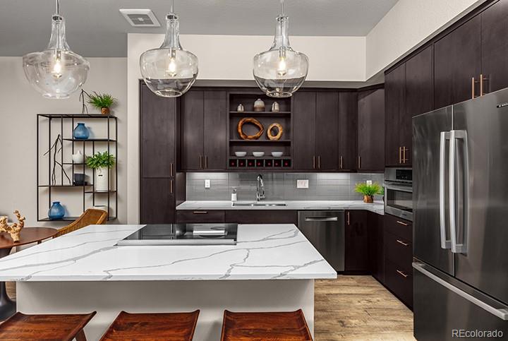 6618 East Lowry Boulevard, Unit 307 Denver, CO 80230 - Photo 5 of 23 a kitchen with stainless steel appliances a table chairs and chandelier