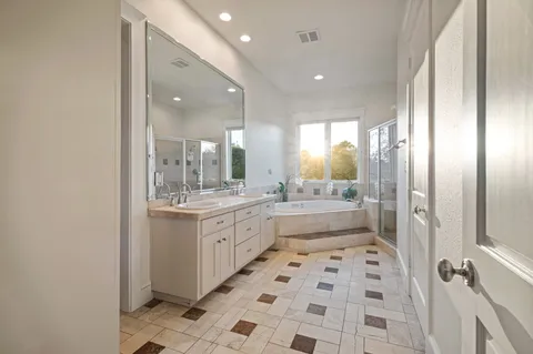 a bathroom with a sink a toilet a mirror and shower