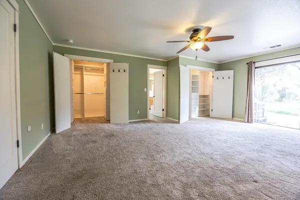 a white house with a big yard and large trees