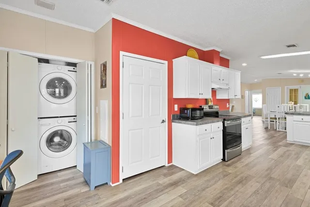a kitchen with a stove a sink and a refrigerator with wooden floor