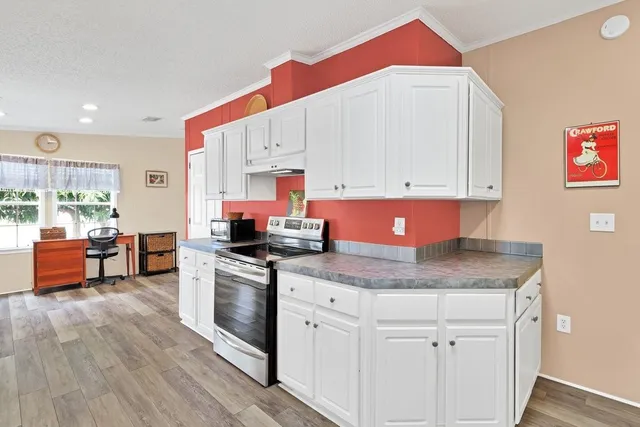 a kitchen with stainless steel appliances granite countertop a stove a sink and a microwave