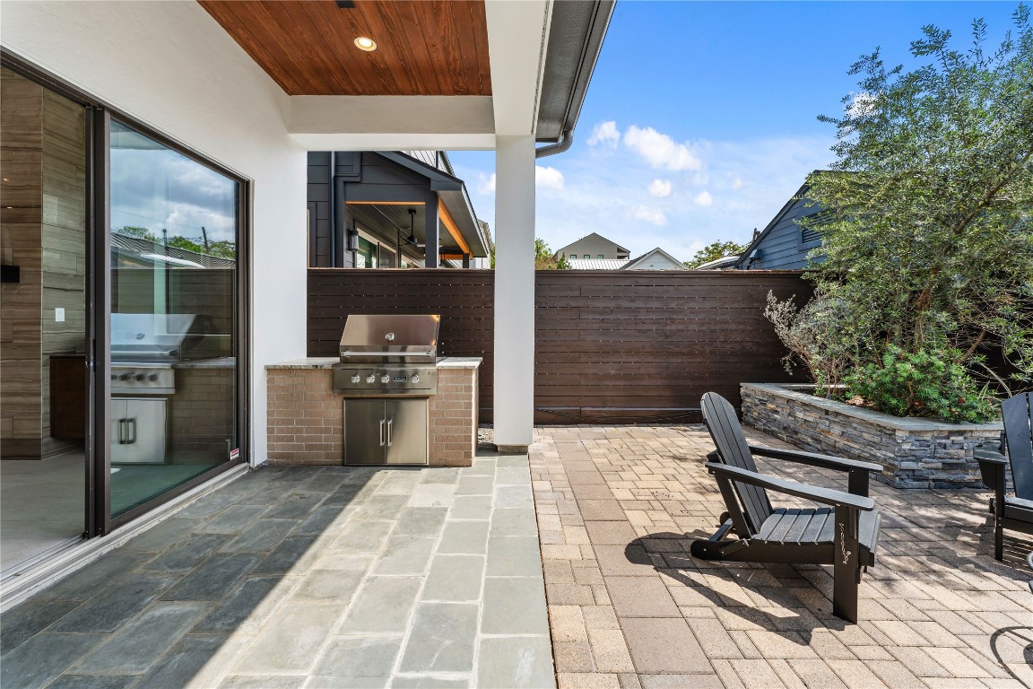 917 Peden Street Houston, TX 77006 - Photo 15 of 50 A fully equipped outdoor kitchen featuring a Viking Professional 5 Series grill anchors this inviting patio space. Surrounded by privacy fencing and thoughtfully designed hardscaping, this area is perfect for hosting gatherings. Covered and open-air zones offer versatility for both dining and lounging.