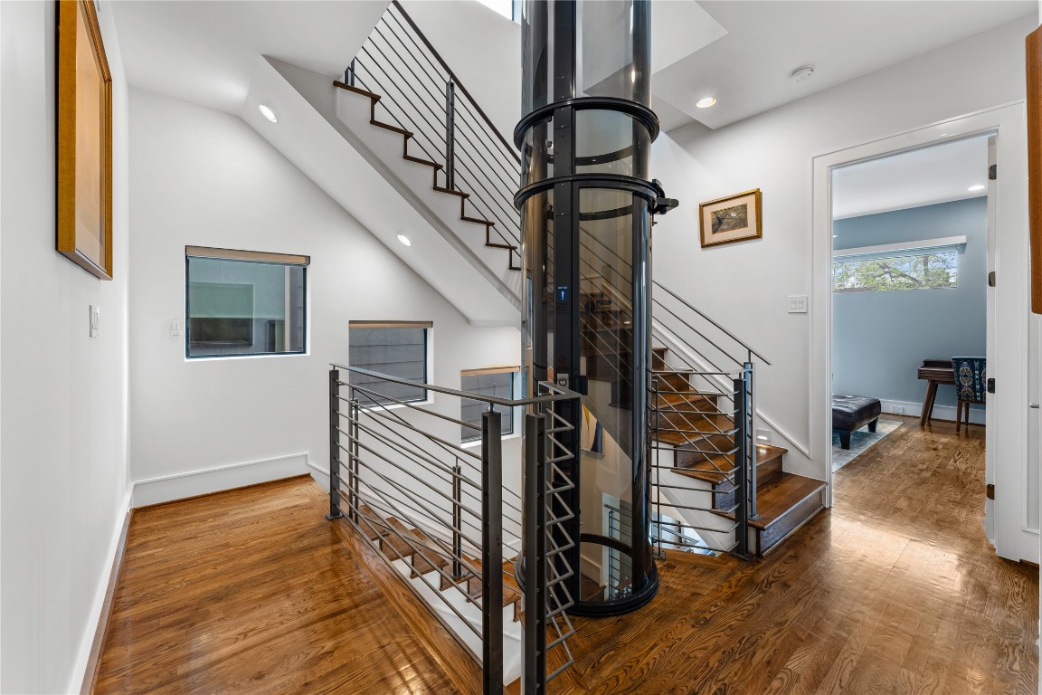 917 Peden Street Houston, TX 77006 - Photo 20 of 50 The upper level showcases stunning warm oak floors and a striking architectural staircase alongside the vacuum elevator. This unique feature adds both convenience and a modern design statement. Thoughtfully designed spaces throughout emphasize luxury and functionality.