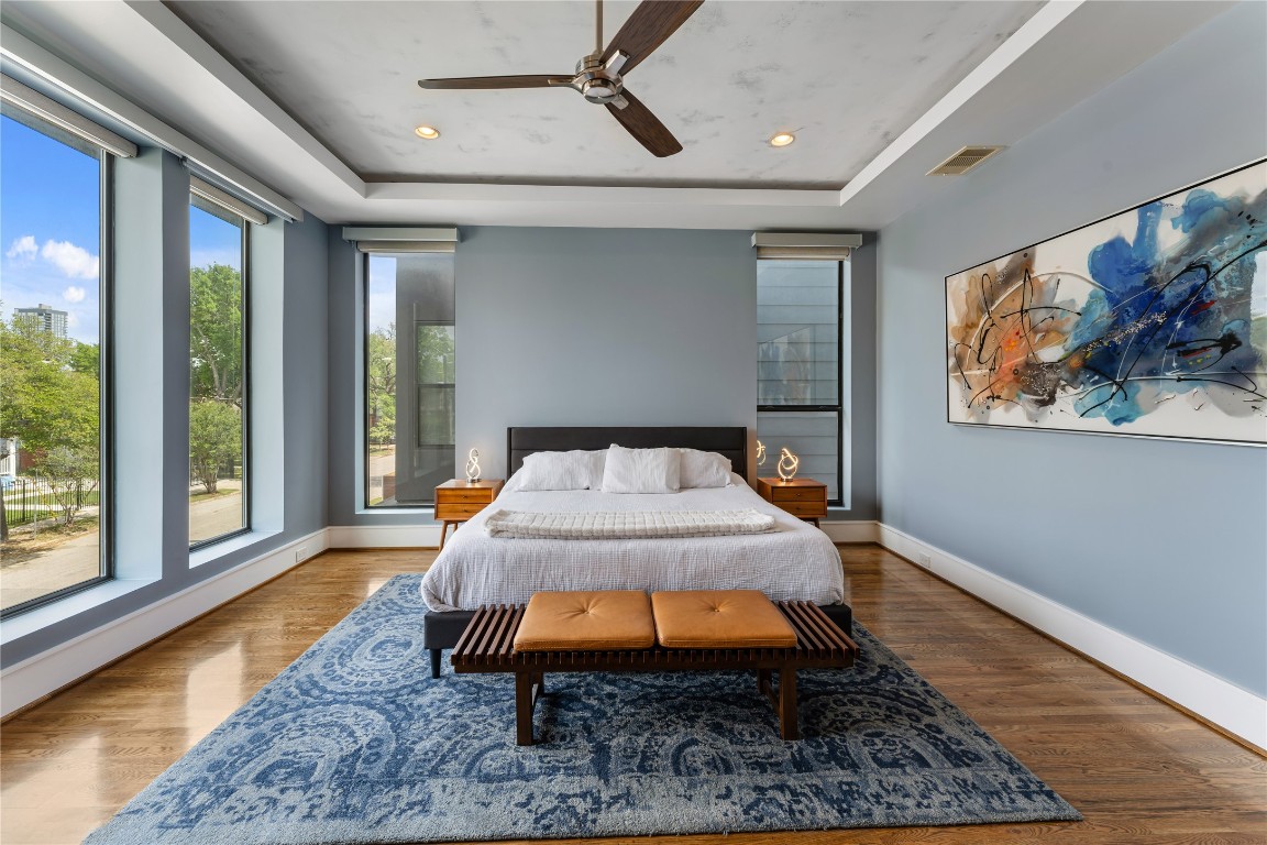 917 Peden Street Houston, TX 77006 - Photo 22 of 50 A luxurious primary suite featuring expansive windows that flood the space with natural light. Soft tones and elegant finishes create a calming, retreat-like atmosphere. The generous layout provides ample space for both relaxation and functionality.