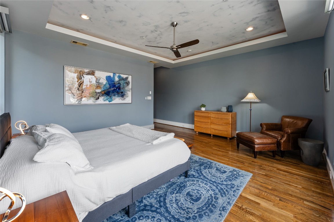 917 Peden Street Houston, TX 77006 - Photo 23 of 50 A spacious primary suite with a dedicated seating area, perfect for reading or unwinding in privacy. Designer finishes and rich wood flooring add warmth and sophistication throughout. This space offers the perfect blend of comfort and elevated design.