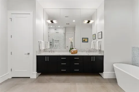 a bathroom with a tub sink shower and mirror