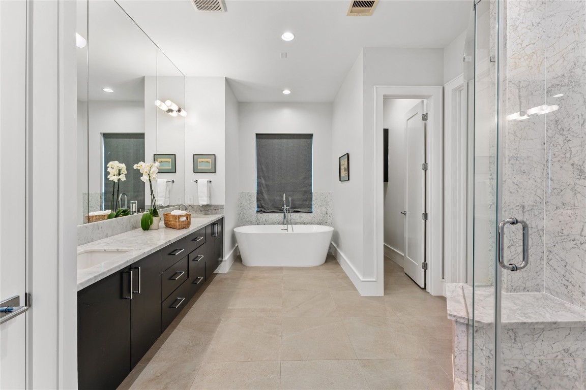 917 Peden Street Houston, TX 77006 - Photo 25 of 50 A spa-inspired primary bathroom featuring marble tile, a freestanding soaking tub, and an oversized walk-in shower. Dual vanities and premium finishes create a refined and relaxing environment. This space delivers both luxury and everyday functionality.