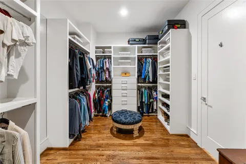 a view of walk in closet with clothes and shoes