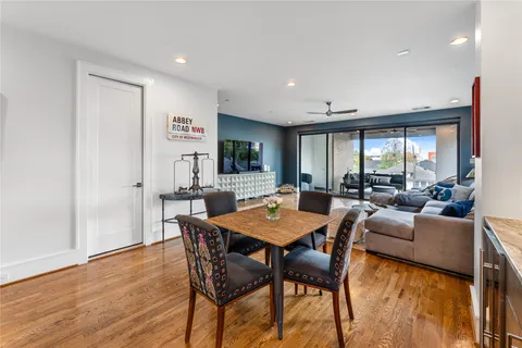 a living room with furniture large window and wooden floor