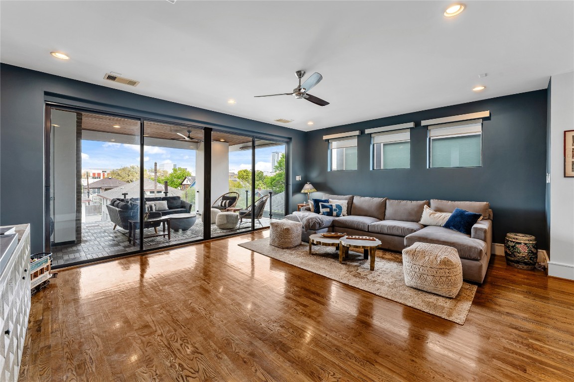 917 Peden Street Houston, TX 77006 - Photo 37 of 50 The spacious living room is anchored by a deep-toned accent wall and framed by large sliding glass doors leading to a private balcony. Natural light fills the space, enhancing its inviting and airy feel. Thoughtful design elements create a perfect balance of comfort and style.
