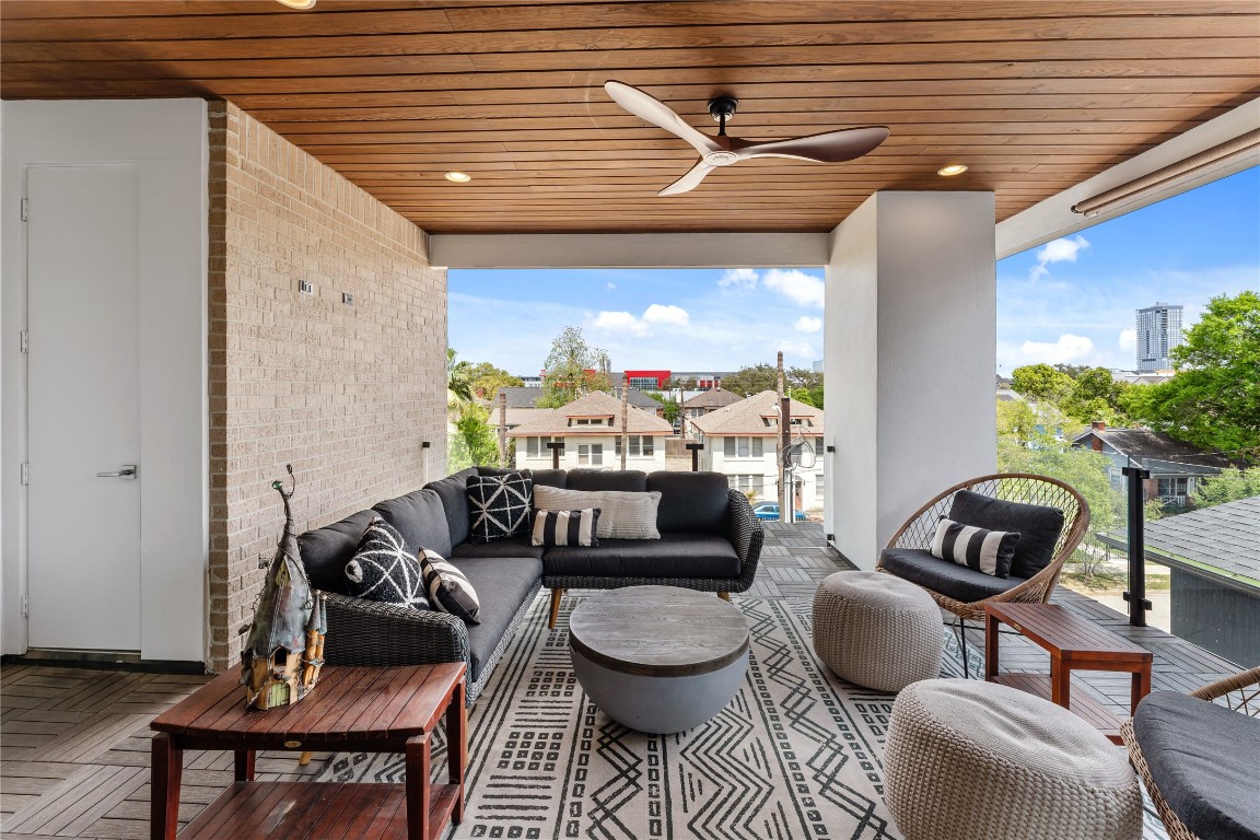 917 Peden Street Houston, TX 77006 - Photo 43 of 50 Designed for elevated outdoor living, this third-floor terrace offers generous seating areas beneath a striking wood-paneled ceiling. Upgraded glass railing enhances the open feel, while electrical for a future TV and a gas connection provide endless possibilities for customization. A perfect setting for relaxing or entertaining in a refined, private retreat.