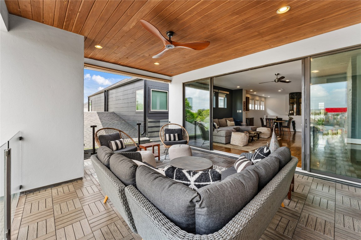 917 Peden Street Houston, TX 77006 - Photo 45 of 50 Experience refined outdoor living on this beautifully appointed third-floor terrace, complete with multiple seating zones and a modern glass railing. The wood-paneled ceiling adds warmth, while built-in electrical for a TV and gas connection offer flexibility for future enhancements. A versatile space designed to elevate both relaxation and entertaining.