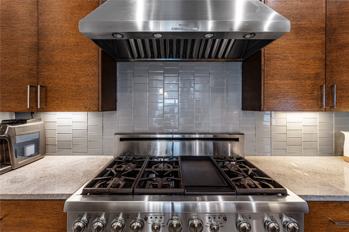 917 Peden Street Houston, TX 77006 - Photo 6 of 50 The Thermador 48" professional series 6-burner gas cooktop with double oven anchors the kitchen with both power and precision. A sleek vent hood and designer tile backsplash create a refined yet functional focal point. This space is built for serious cooking while maintaining a luxurious aesthetic.