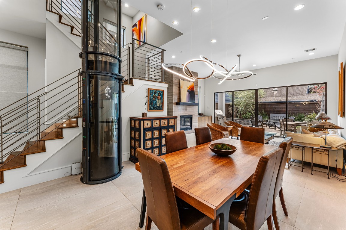 917 Peden Street Houston, TX 77006 - Photo 9 of 50 An impressive open layout connects dining and living areas, ideal for entertaining on any scale. Expansive sliding glass doors create a seamless indoor-outdoor transition, inviting natural light and fresh air inside. Custom finishes and thoughtful upgrades elevate every corner of this home.