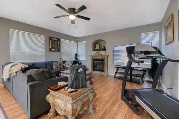 a living room with furniture a clock on wall and a window