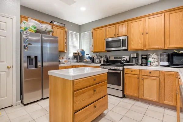 a kitchen with stainless steel appliances granite countertop a stove a sink and a refrigerator