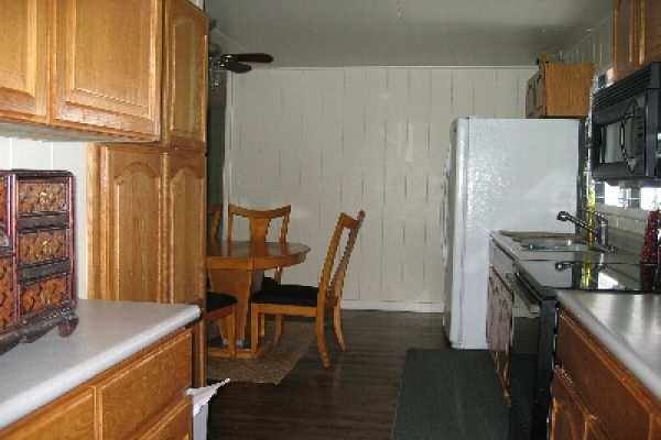 82-1052 Kinue Road Captain Cook, HI 96704 - Photo 3 of 9 a kitchen with stainless steel appliances granite countertop a table chairs and a refrigerator
