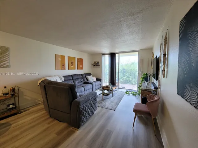 a living room with furniture wooden floor and a window
