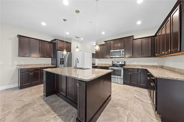 a large kitchen with stainless steel appliances granite countertop a stove and a sink