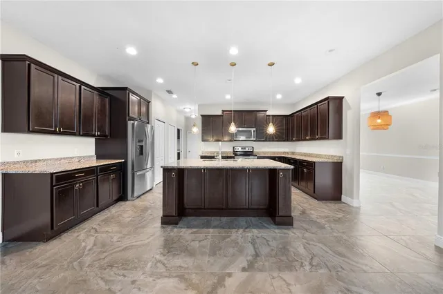 a large kitchen with stainless steel appliances granite countertop plenty wooden cabinets and granite counter tops