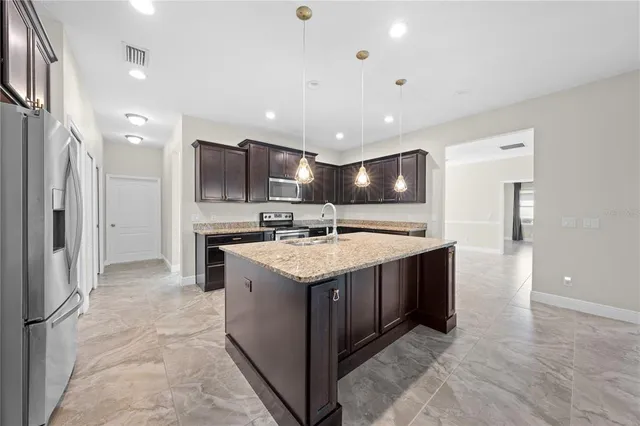 a kitchen with stainless steel appliances granite countertop a stove a sink and a refrigerator