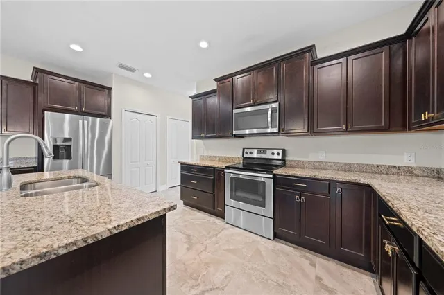 a view of empty room with a kitchen