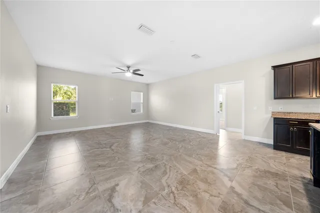 an empty room with fan and windows