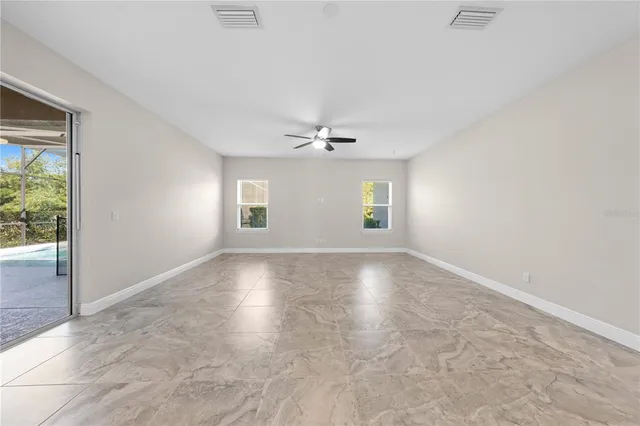 an empty room with a window and a ceiling fan