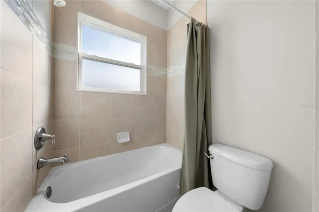 a view of an empty room with closet and a window