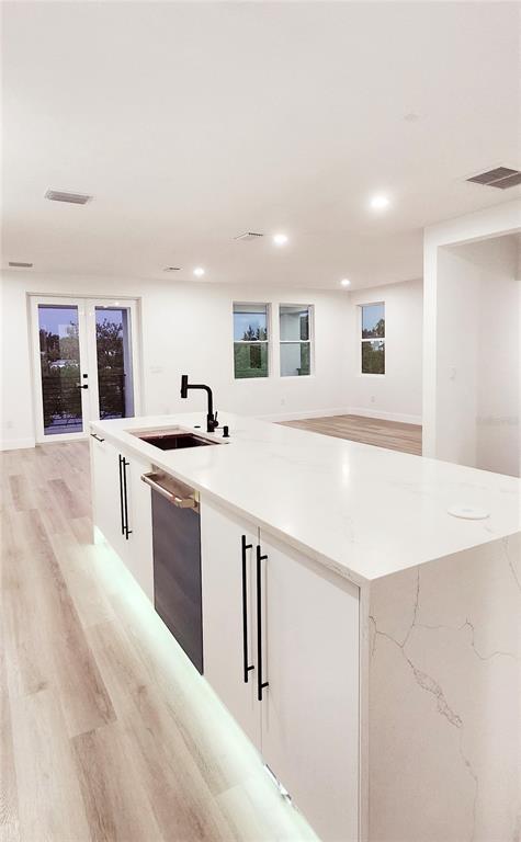 7609 Deedra Circle Port Richey, FL 34668 - Photo 20 of 63 a large kitchen with stainless steel appliances a sink dishwasher a stove and a refrigerator with wooden floor