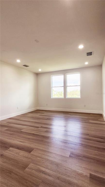 7609 Deedra Circle Port Richey, FL 34668 - Photo 41 of 63 an empty room with wooden floor and windows