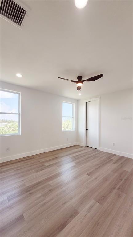 7609 Deedra Circle Port Richey, FL 34668 - Photo 45 of 63 an empty room with wooden floor ceiling fan and windows