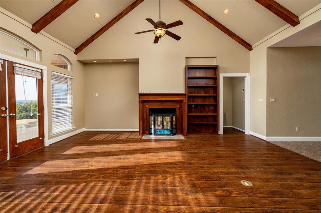 270 Stone Mountain Road Cresson, TX 76035 - Photo 10 of 40 a view of an empty room with wooden floor fireplace and a window