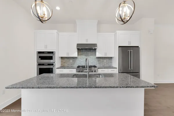 a kitchen with granite countertop a stove and cabinets