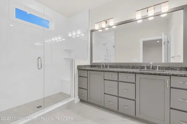 a bathroom with a granite countertop sink a shower and a mirror