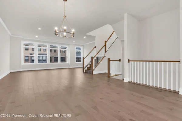 a view of a livingroom with wooden floor and stairs