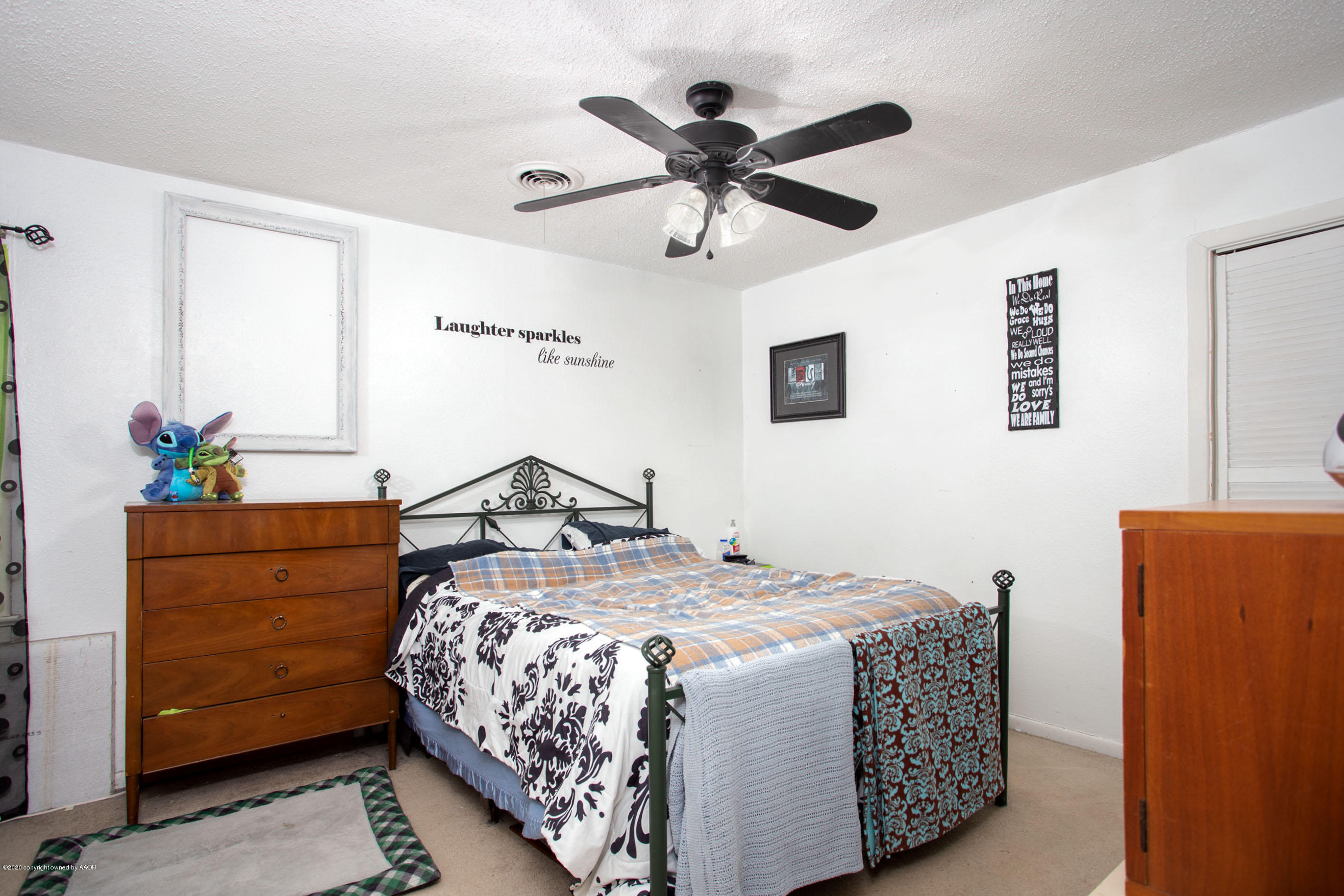4226 South Harrison Street Amarillo, TX 79110 - Photo 8 of 17 a bedroom with a bed and a chandelier