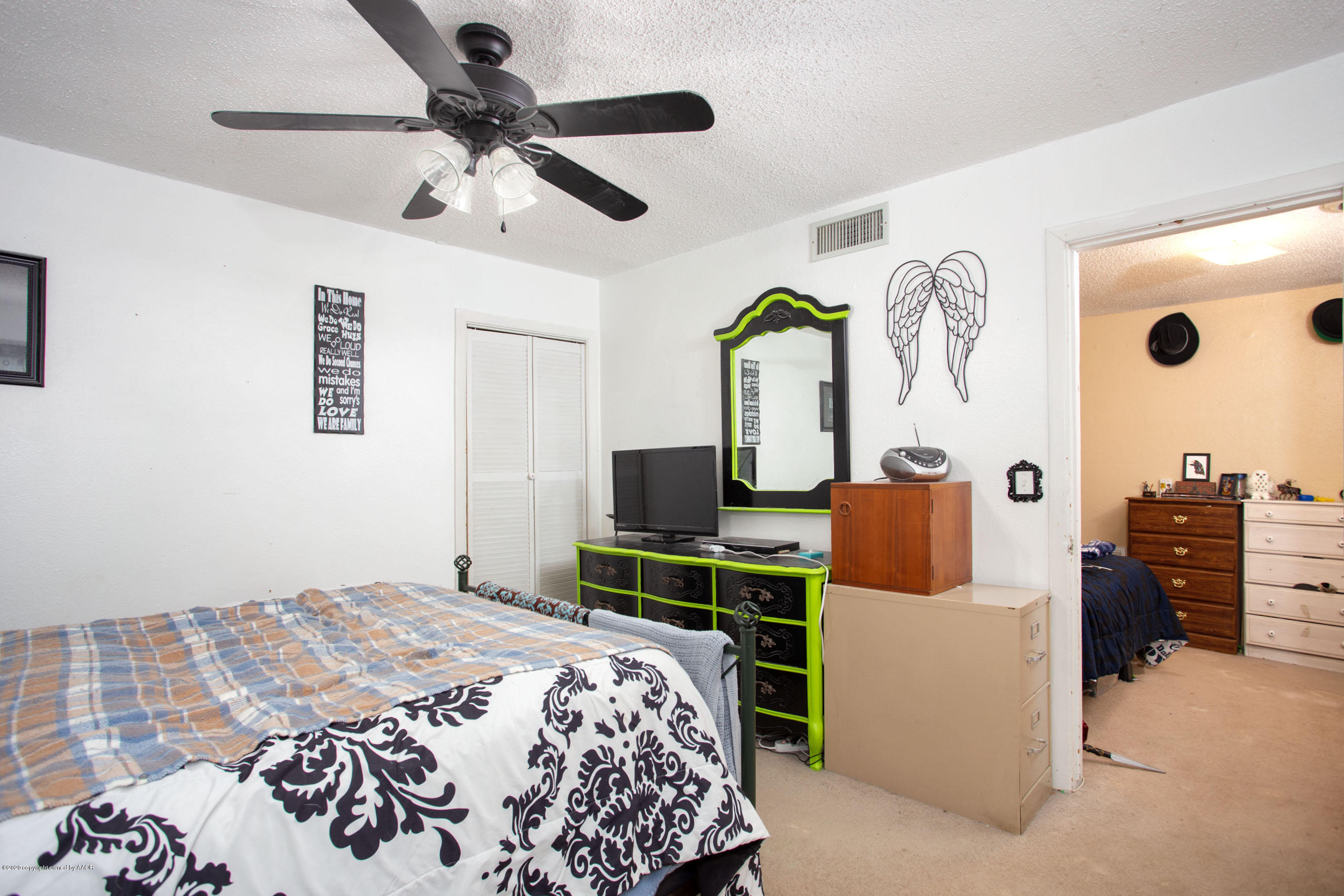 4226 South Harrison Street Amarillo, TX 79110 - Photo 9 of 17 a bedroom with a bed and a chandelier