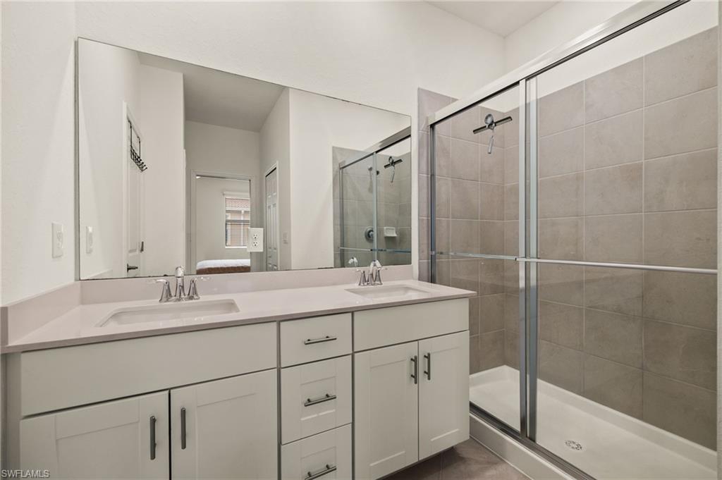 2934 Citrus Street Naples, FL 34120 - Photo 14 of 29 a bathroom with a double vanity sink toilet mirror and shower
