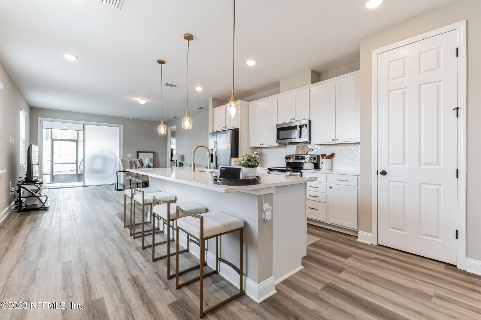 7062 Red Timber Road Jacksonville, FL 32244 - Photo 13 of 31 a kitchen with stainless steel appliances kitchen island granite countertop a table chairs refrigerator and microwave
