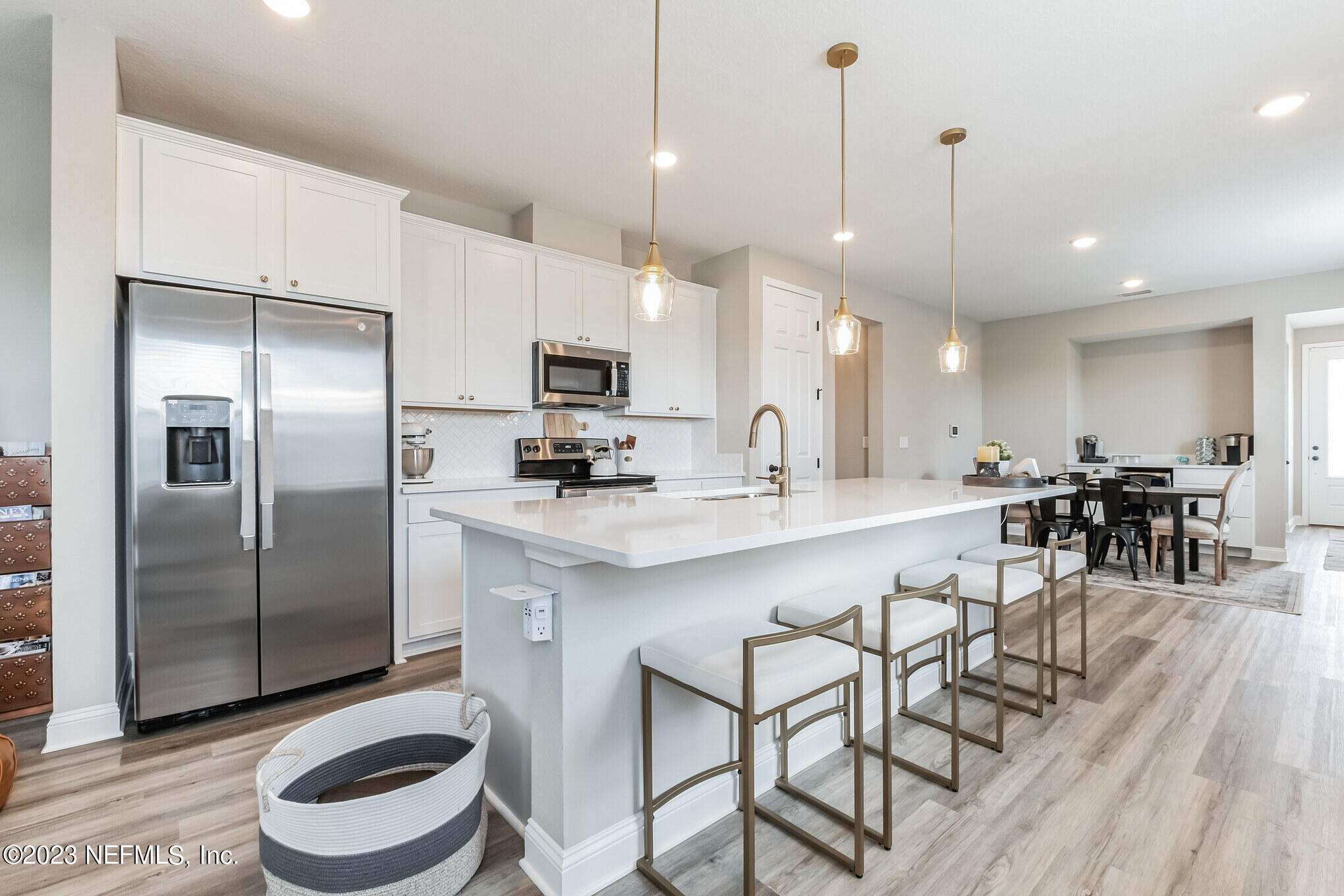 7062 Red Timber Road Jacksonville, FL 32244 - Photo 14 of 31 a kitchen with kitchen island a dining table chairs sink and microwave